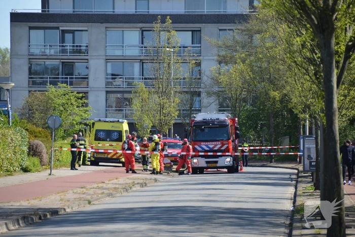Brandweer in beschermende pakken halen persoon uit woning
