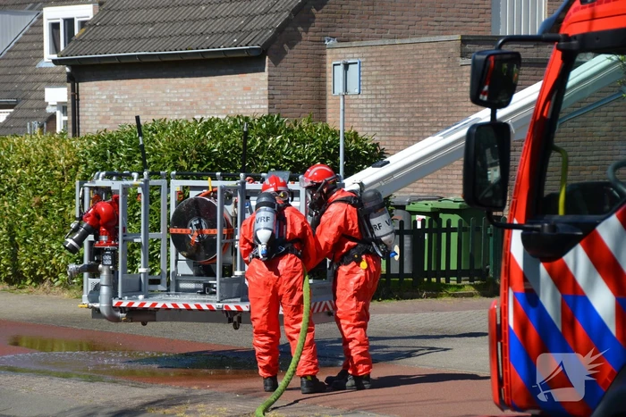 Brandweer in beschermende pakken halen persoon uit woning