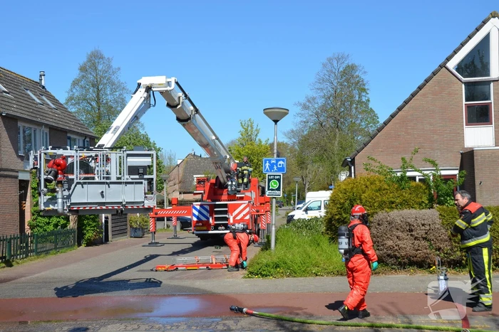 Brandweer in beschermende pakken halen persoon uit woning
