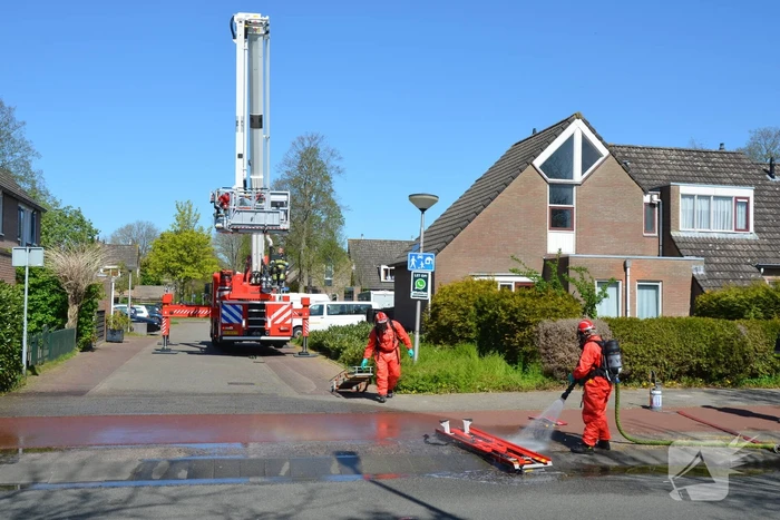 Brandweer in beschermende pakken halen persoon uit woning