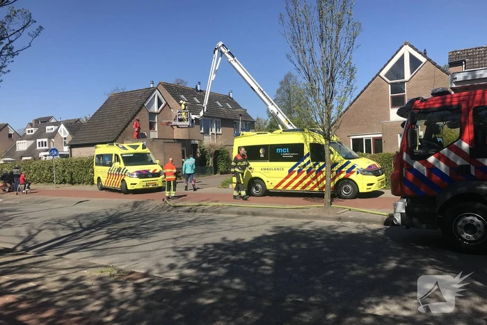 Brandweer in beschermende pakken halen persoon uit woning