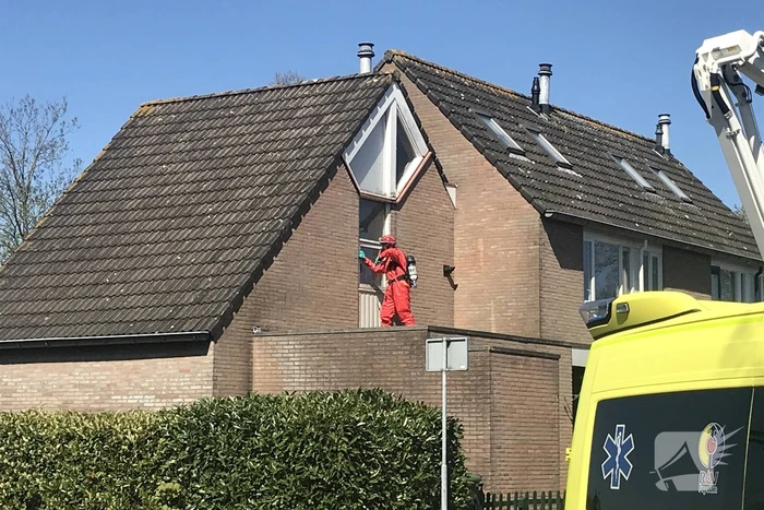 Brandweer in beschermende pakken halen persoon uit woning