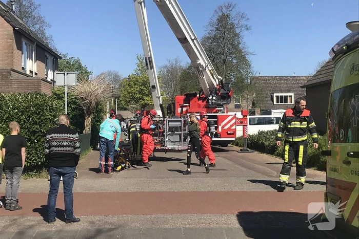 Brandweer in beschermende pakken halen persoon uit woning