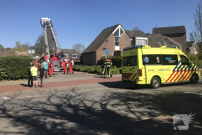 Brandweer in beschermende pakken halen persoon uit woning