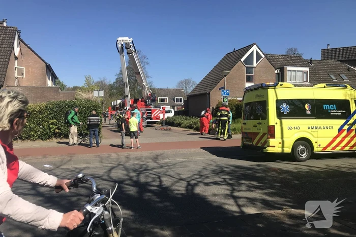 Brandweer in beschermende pakken halen persoon uit woning