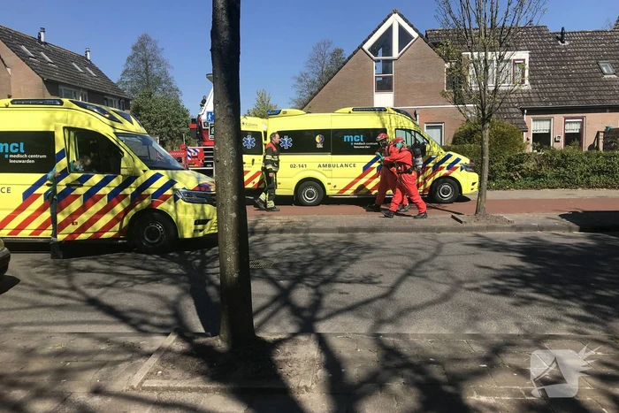 Brandweer in beschermende pakken halen persoon uit woning