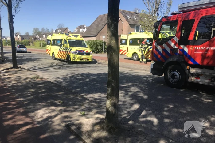 Brandweer in beschermende pakken halen persoon uit woning