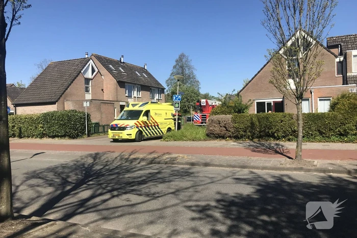 Brandweer in beschermende pakken halen persoon uit woning