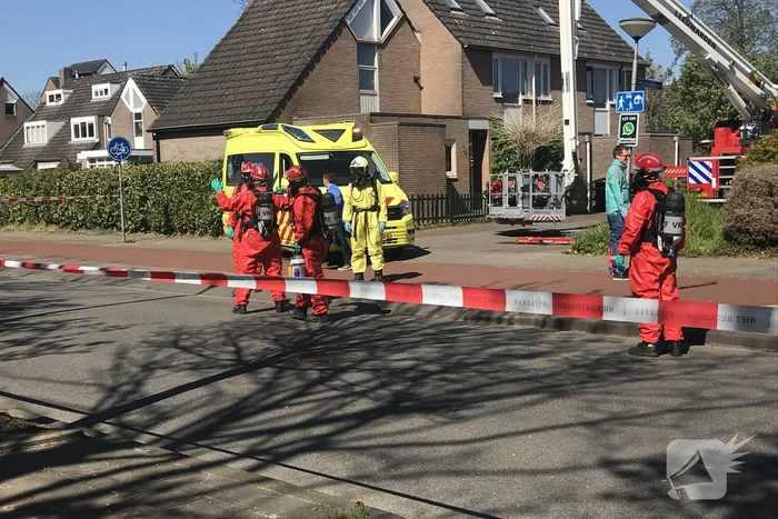 Brandweer in beschermende pakken halen persoon uit woning