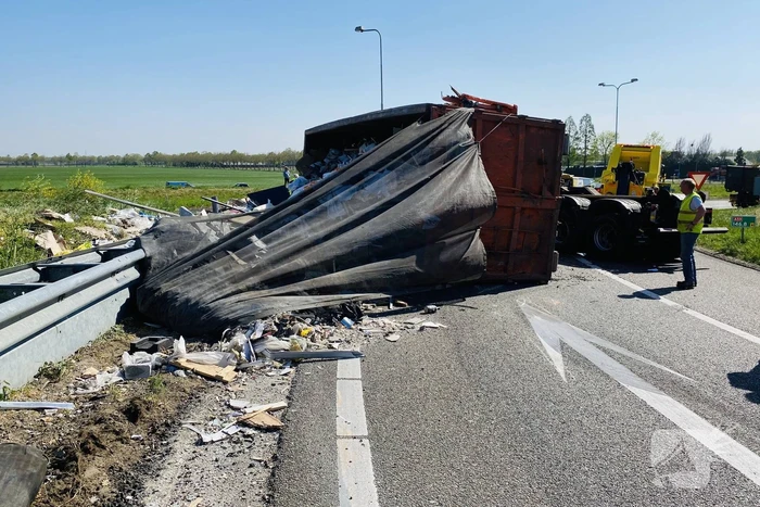 Vrachtwagen met afval gekanteld op afrit