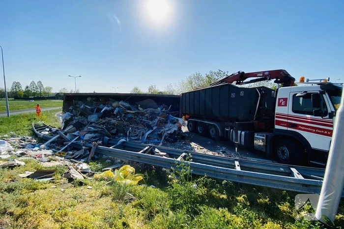 Vrachtwagen met afval gekanteld op afrit