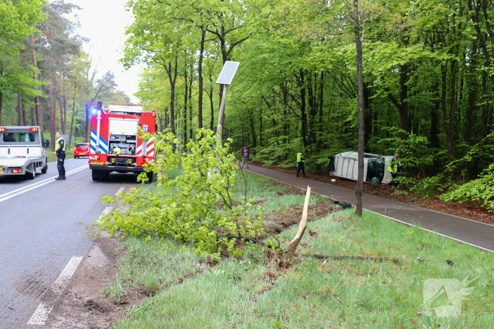 Bestelbus belandt op zijn kant in bosschage