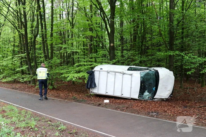 Bestelbus belandt op zijn kant in bosschage