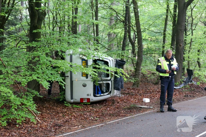 Bestelbus belandt op zijn kant in bosschage