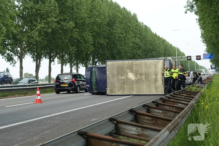 Bestelbus belandt op zijn kant, vrachtwagen ramt vangrail