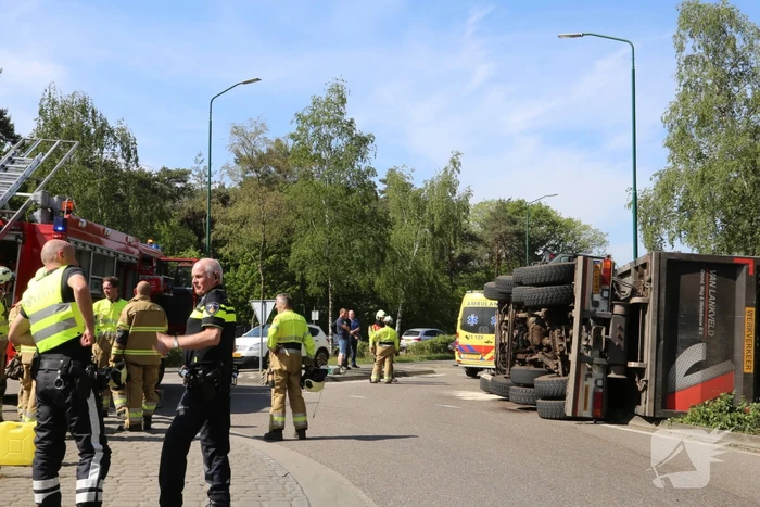 Vrachtwagen met tuinafval gekanteld op rotonde