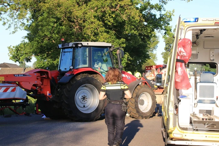 Scooter en scooterrijder bekneld onder tractor na ongeval