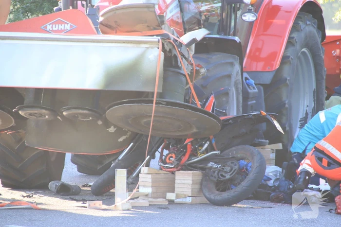 Scooter en scooterrijder bekneld onder tractor na ongeval