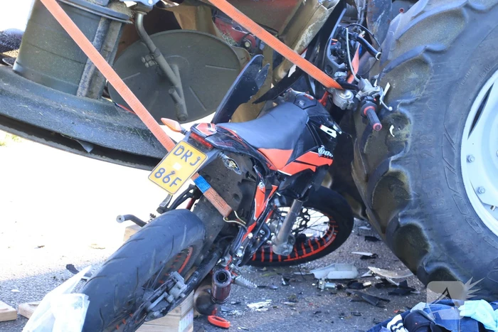 Scooter en scooterrijder bekneld onder tractor na ongeval