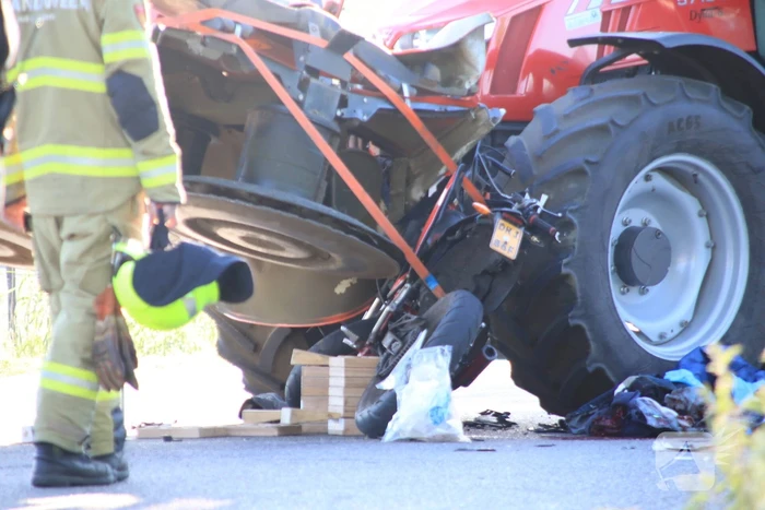 Scooter en scooterrijder bekneld onder tractor na ongeval