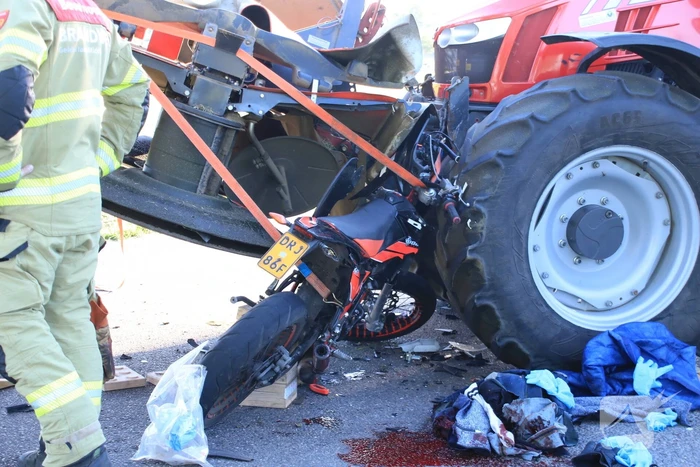Scooter en scooterrijder bekneld onder tractor na ongeval