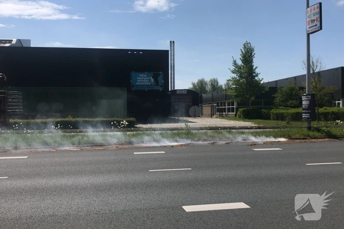 Brandweer blust brandend gras in berm