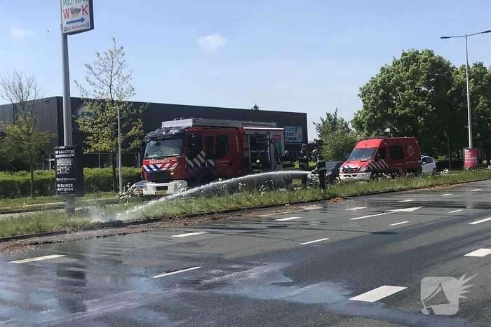 Brandweer blust brandend gras in berm