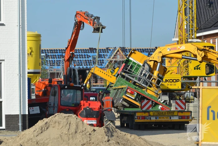 Vrachtwagen zakt door stempel bouwterrein