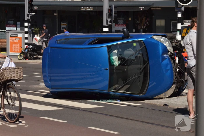 Auto crasht en belandt op zijn kant