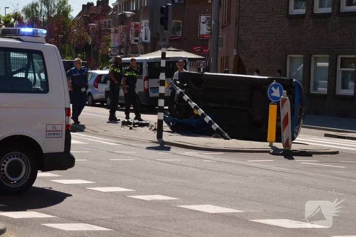Auto crasht en belandt op zijn kant