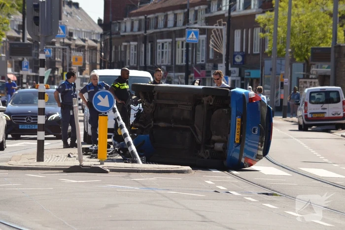 Auto crasht en belandt op zijn kant