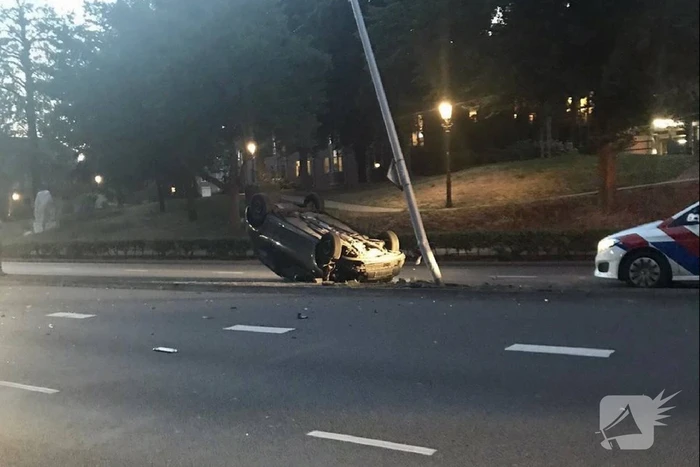 Auto knalt op lantaarnpaal en belandt op de kop