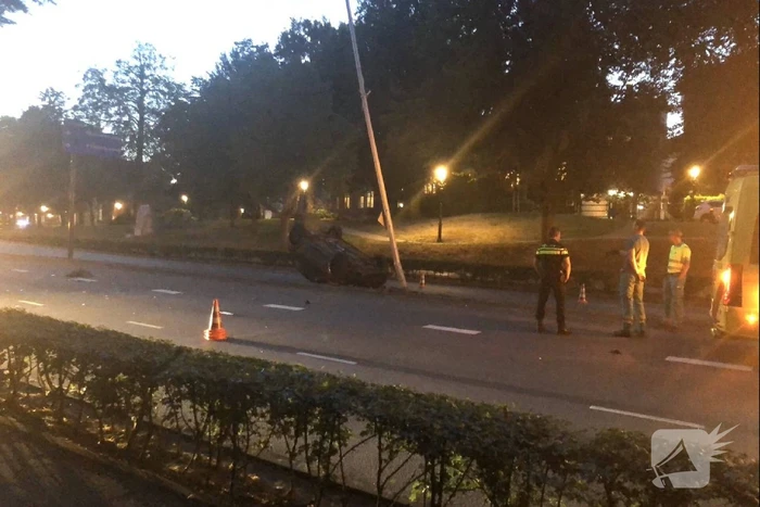 Auto knalt op lantaarnpaal en belandt op de kop