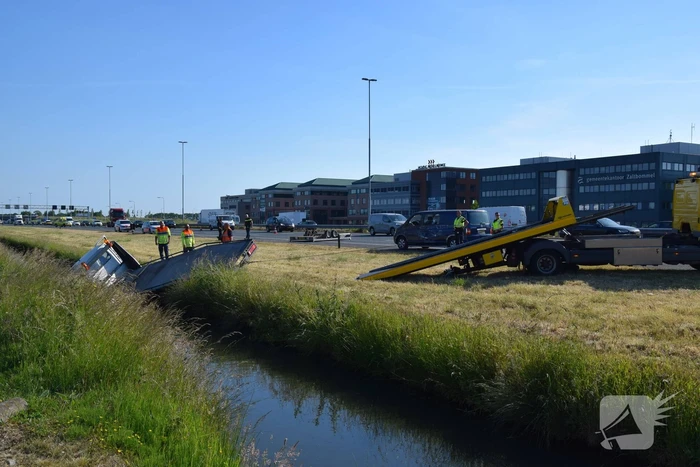Bestelbus op zijn kant autoambulance in de sloot