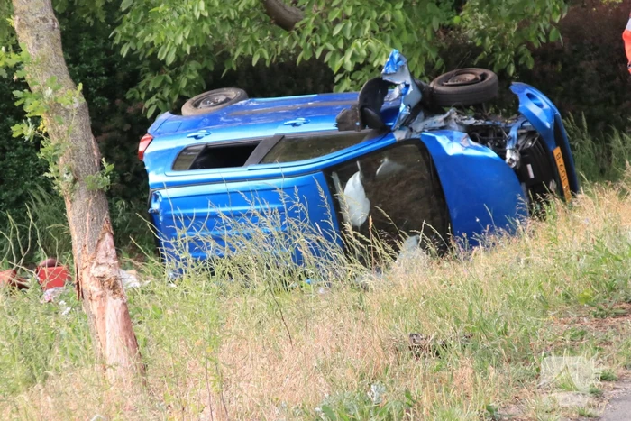 Auto belandt op zijn kant in weiland
