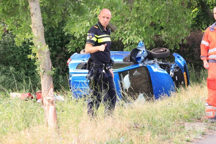 Auto belandt op zijn kant in weiland