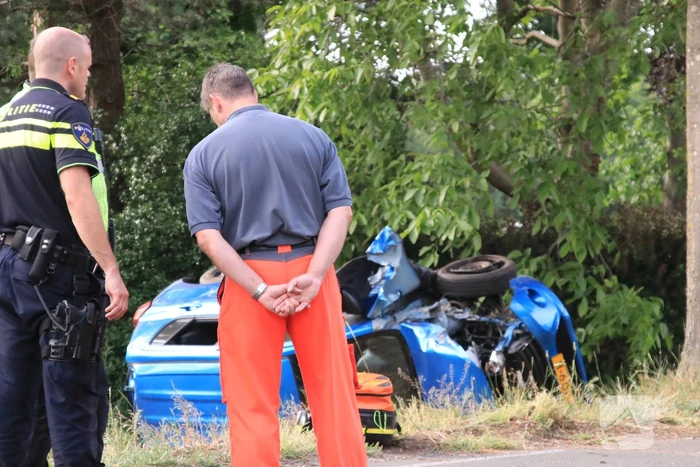 Auto belandt op zijn kant in weiland