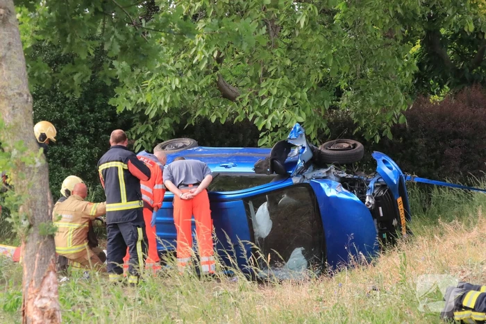 Auto belandt op zijn kant in weiland