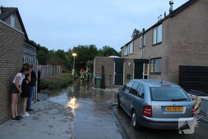 Groot sinkhole en straat vol water na leidingbreuk