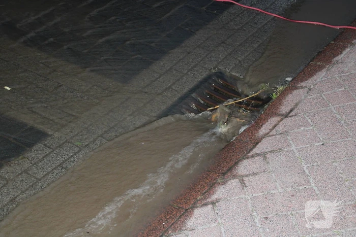 Groot sinkhole en straat vol water na leidingbreuk