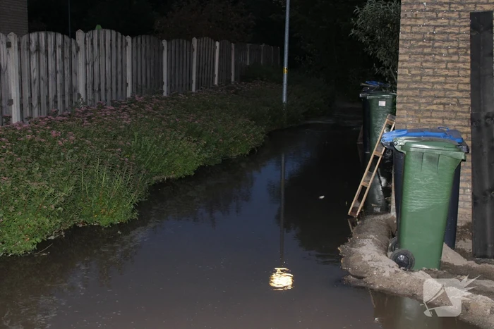 Groot sinkhole en straat vol water na leidingbreuk