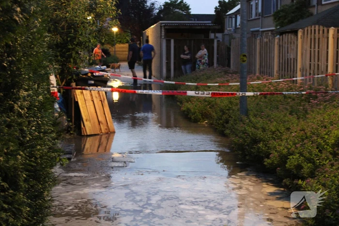Groot sinkhole en straat vol water na leidingbreuk