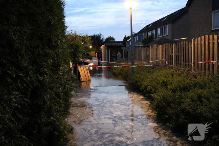 Groot sinkhole en straat vol water na leidingbreuk