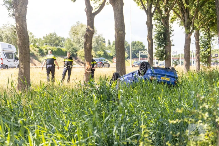 Auto raakt van snelweg en belandt op de kop