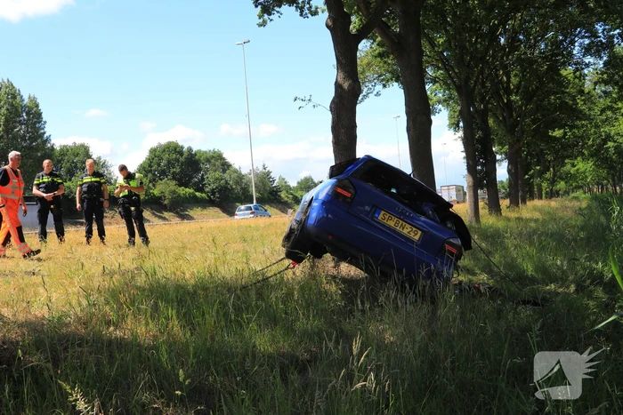 Auto raakt van snelweg en belandt op de kop