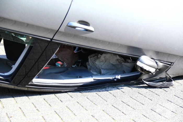 Auto op zijn kop na aanrijding met geparkeerde auto