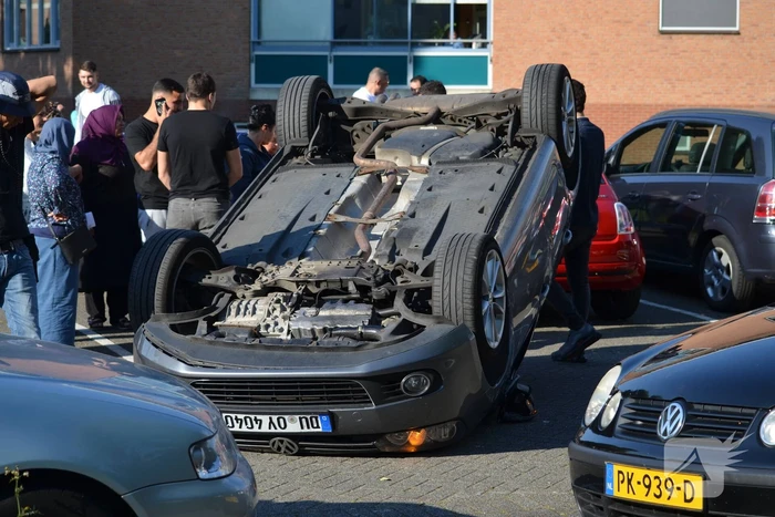 Auto op zijn kop na aanrijding met geparkeerde auto
