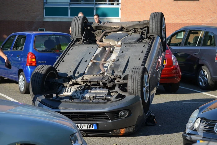 Auto op zijn kop na aanrijding met geparkeerde auto
