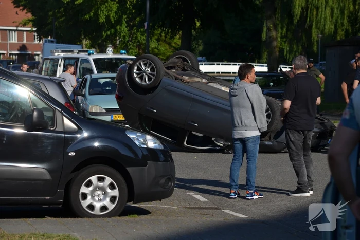 Auto op zijn kop na aanrijding met geparkeerde auto