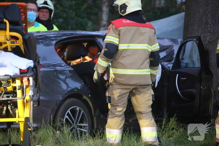 Bestuurder bekneld bij botsing tegen boom